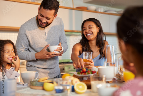Joyful family having breakfast together in pajamas