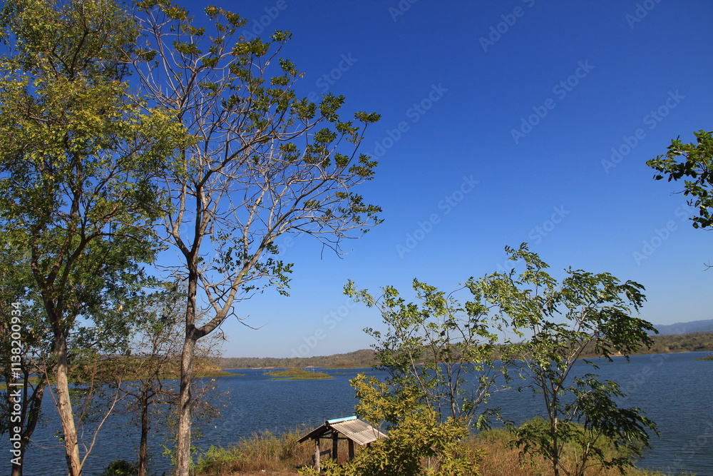 Natural tourist attractions with a large river, trees, and a bright sky background. Natural tourist attractions with a large river, trees, and a bright sky background.