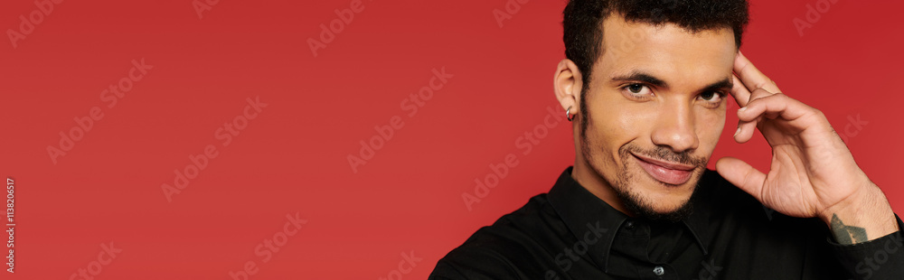 A young man poses confidently with a smile while touching his face, showcasing charm and style. A young man poses confidently with a smile while touching his face, showcasing charm and style.