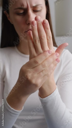 Vertical video of unhealthy female massage hand with wrist pain, rheumatoid arthritis. Young woman suffer from numbing pain in hand, numbness fingertip, arthritis inflammation, peripheral neuropathies