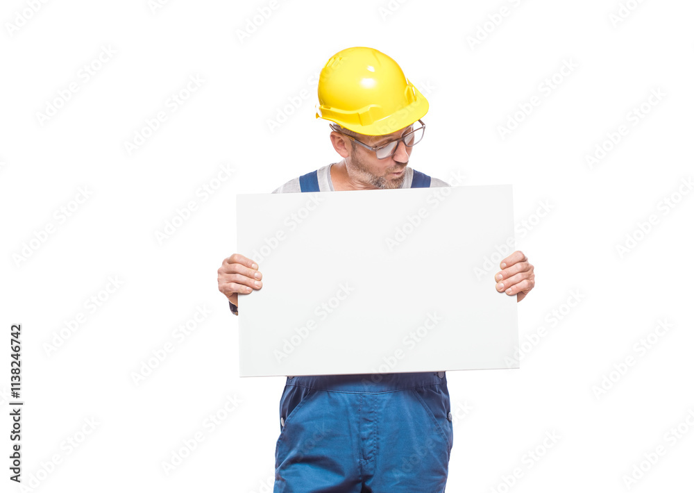 Surprised construction worker holding white board, isolated on white background. Promoting repairman showing blank empty paper billboard with blank space for text. Craftsman against white wall Surprised construction worker holding white board, isolated on white background. Promoting repairman showing blank empty paper billboard with blank space for text. Craftsman against white wall