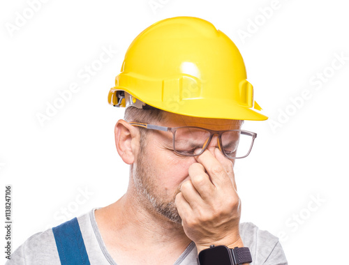 Drowsy middle-aged construction worker looking at camera, isolated on white background. Close-up exhausted repairman. Sleepy expression. Craftsman against white wall