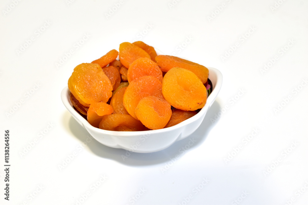 Dried apricots, dried apricots, in a deep plate on a white background. Dried apricots, dried apricots, in a deep plate on a white background.