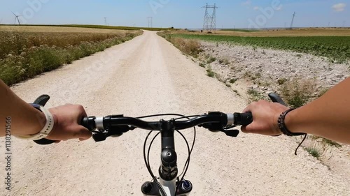 Man riding bicycle on dirt path in countryside on a sunny summer day. Cycling outdoors natural park. POV. High quality 4k footage