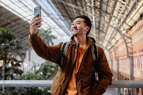 Young man taking a selfie at atocha station in madrid