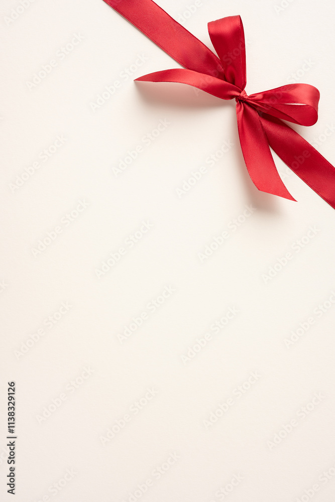 A vertical beautifully tied red ribbon bow against a neutral backdrop, symbolizing elegance and simplicity. Perfect for themes of gift-giving, celebrations, special occasions with a touch of charm A vertical beautifully tied red ribbon bow against a neutral backdrop, symbolizing elegance and simplicity. Perfect for themes of gift-giving, celebrations, special occasions with a touch of charm