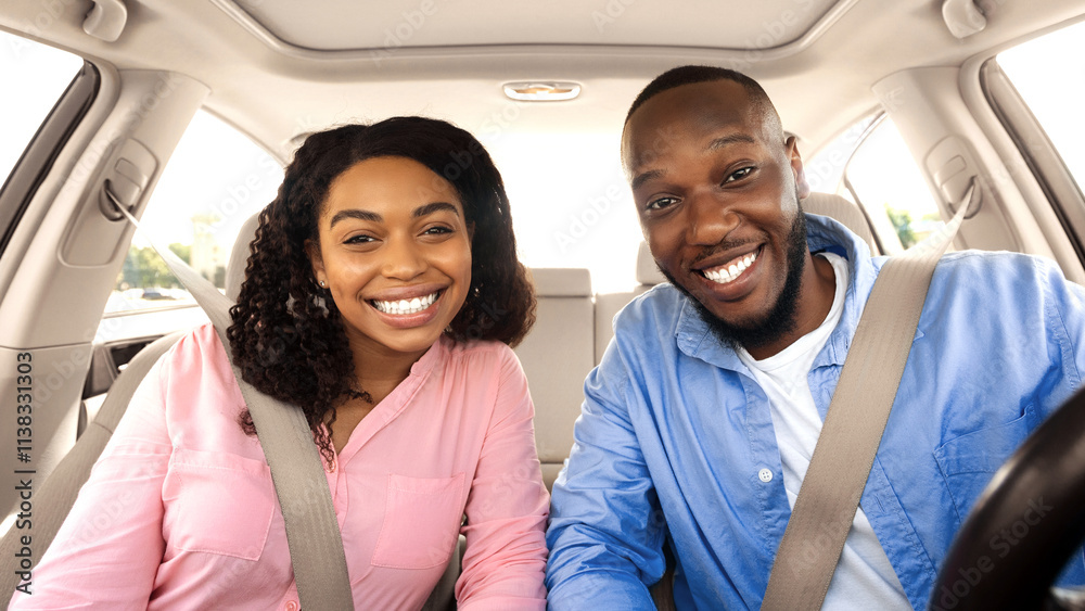 Front portrait of smiling beautiful African American couple sitting in modern luxury car, happy excited young man and woman posing looking at camera, enjoying road trip or buying new car Front portrait of smiling beautiful African American couple sitting in modern luxury car, happy excited young man and woman posing looking at camera, enjoying road trip or buying new car