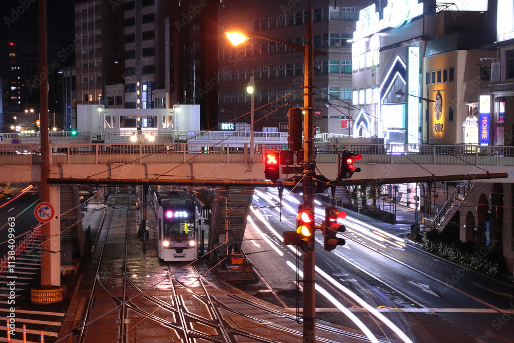 Fototapeta premium 夜の長崎の街並みの中停車する路面電車(長崎電気軌道5000形)_2023/1/15撮影