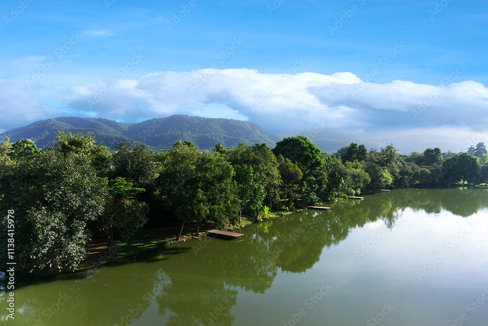 Panoramic view of a tranquil mountain river flowing through a lush valley with towering peaks and clear skies. Panoramic view of a tranquil mountain river flowing through a lush valley with towering peaks and clear skies.