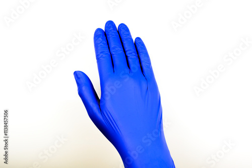 hand wearing a blue nitrile glove against a plain white background. 