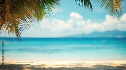 Tranquil blurred ocean landscape with palm leaves framing a serene sandy beach and soft blue sky background. Perfect for relaxation themes.