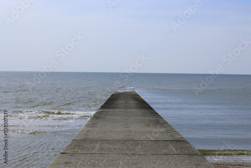 Wellenbrecher am Strand der Insel Borkum ragt in die Nordsee hinein photo