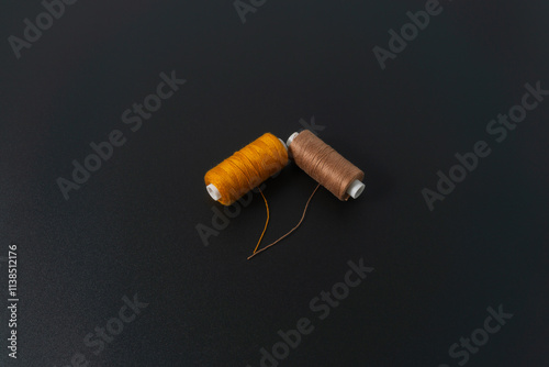 Spun polyester sewing thread on black background