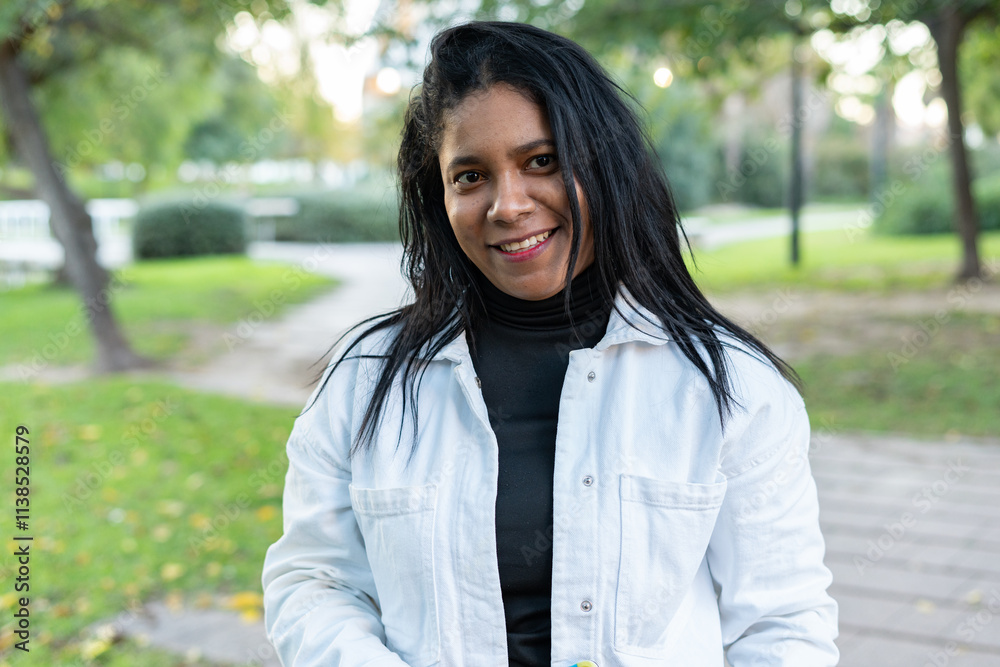 Smiling woman wearing white jacket and black shirt in park Smiling woman wearing white jacket and black shirt in park