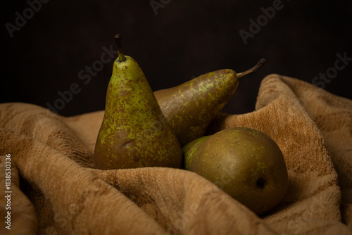 View of three pears on cloth, brown background, horizontal with copy space