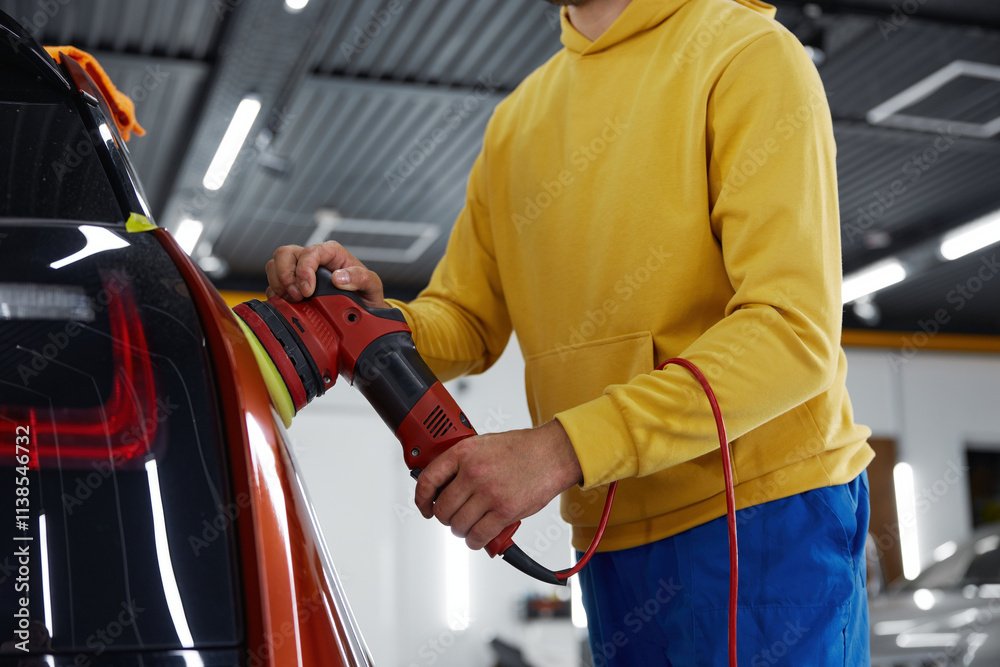 Male auto master providing professional detailing service in car studio Male auto master providing professional detailing service in car studio