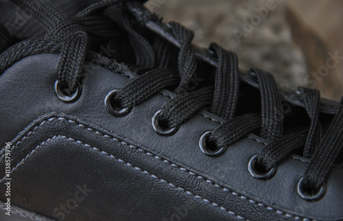 black shoe laces on sports leather shoes close-up