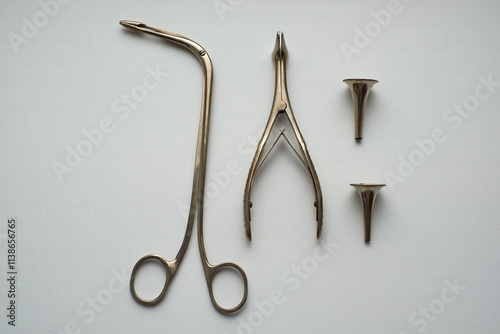 On the table are a nasal speculum, laryngeal forceps, ear funnels. Medical instruments for an otolaryngologist.