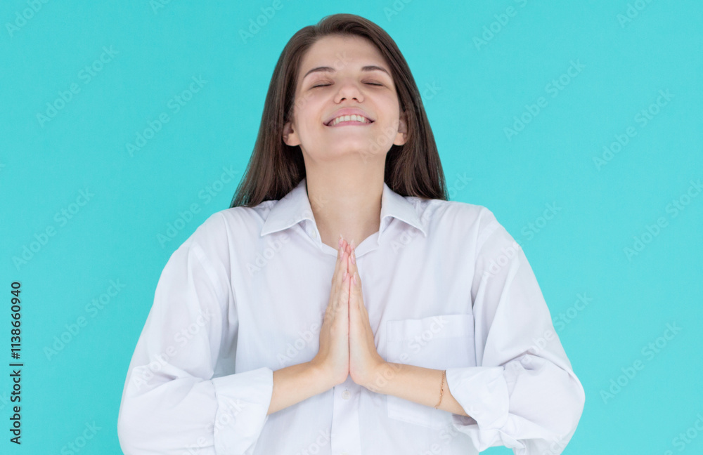 Portrait of redhead young woman holds hands together, namaste gesture, say thank you, grateful, express gratitude and joy, stands over blue background. copy space Portrait of redhead young woman holds hands together, namaste gesture, say thank you, grateful, express gratitude and joy, stands over blue background. copy space