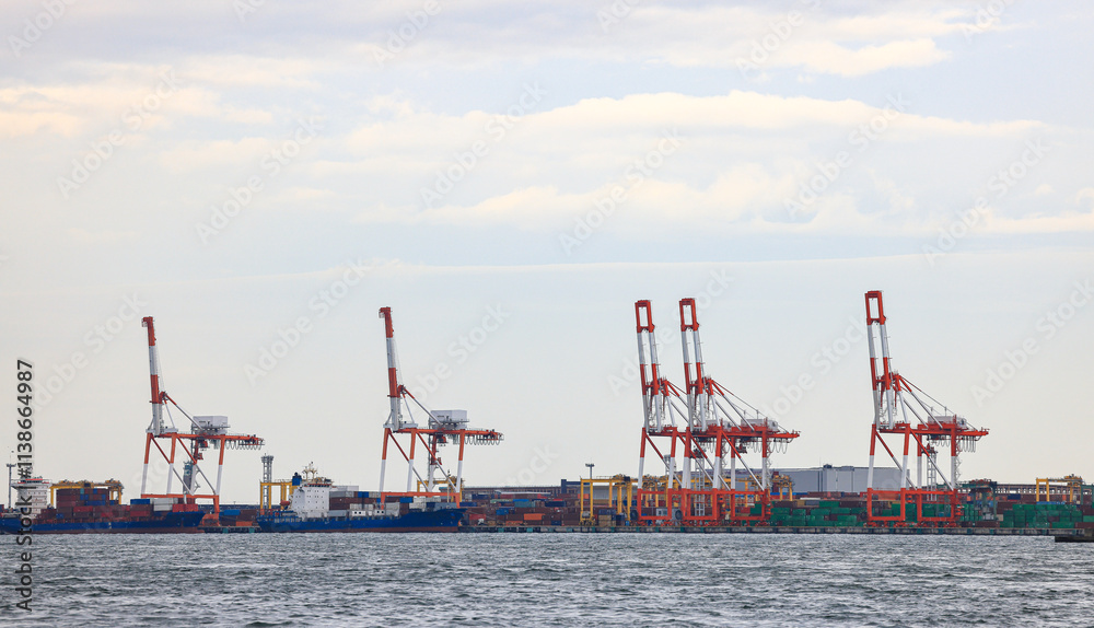 Container port at Osaka Japan, container crane at Industrial port for cargo container ship. Cargo transportation and activity at modern shipping container terminal. Container port at Osaka Japan, container crane at Industrial port for cargo container ship. Cargo transportation and activity at modern shipping container terminal.