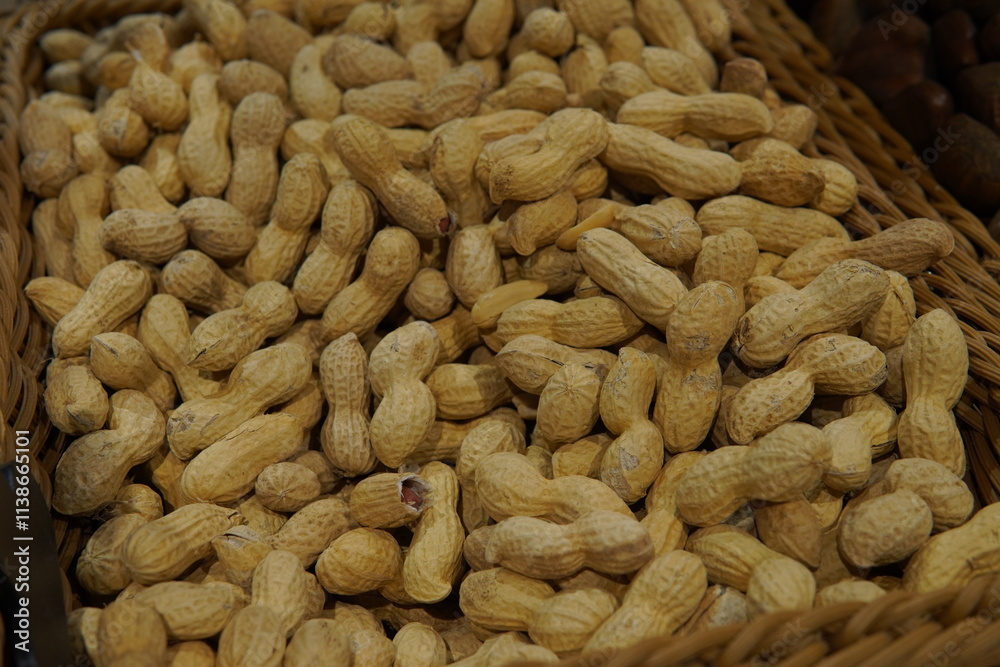 Peanuts in a wicker basket. Brown tones of chestnuts. Seasonal product, natural food, autumn harvest Peanuts in a wicker basket. Brown tones of chestnuts. Seasonal product, natural food, autumn harvest