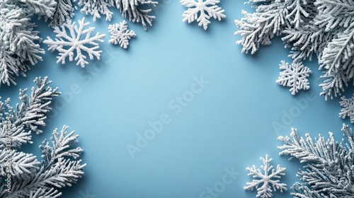 Winter wonderland background with snowflakes and pine branches on blue surface