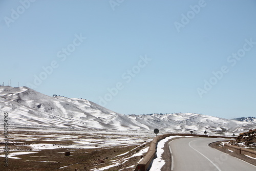 A winter landscape with mountains and snow on the peaks