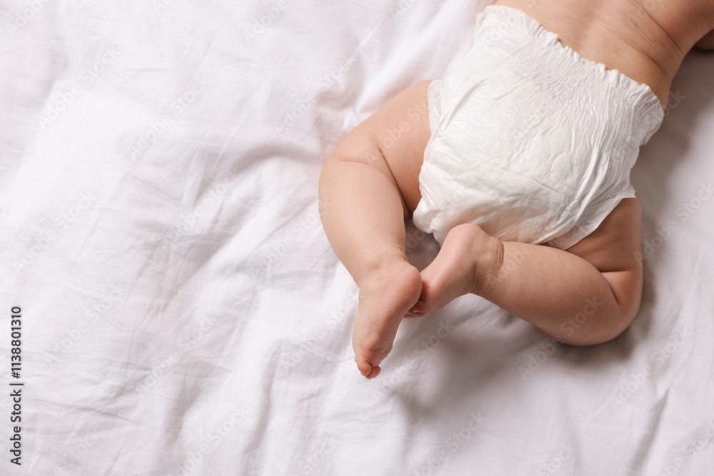 Cute little baby in diaper on bed, top view. Space for text Cute little baby in diaper on bed, top view. Space for text