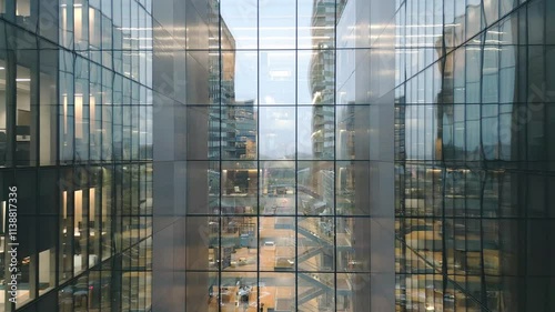 Vilnius, Lithuania -28th november, 2024: aerial view office worker walk in glass business building with reflections of modern office interior. Anteja medical clinic. Telia telecommunications company