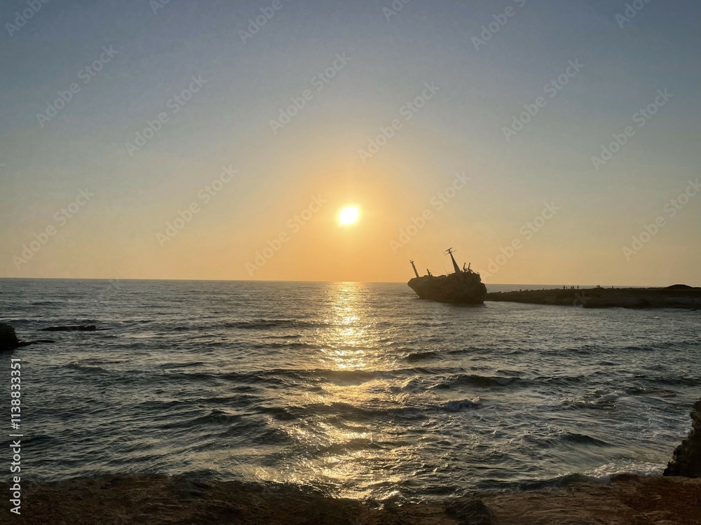 Shipwreck at Sunset with Golden Reflections on the Calm Sea in Pegeia, Paphos, Cyprus Shipwreck at Sunset with Golden Reflections on the Calm Sea in Pegeia, Paphos, Cyprus