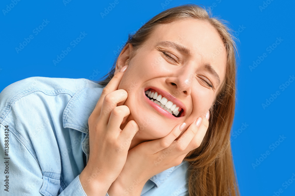 Emotional young woman suffering from toothache on blue background Emotional young woman suffering from toothache on blue background