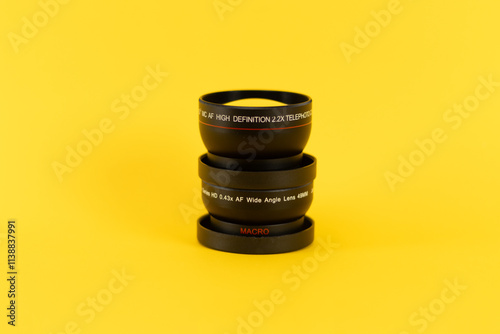 bunch of lenses from a professional camera in a yellow background