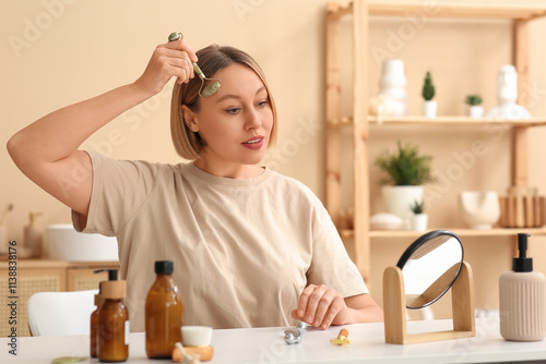 Woman using face massage ro...