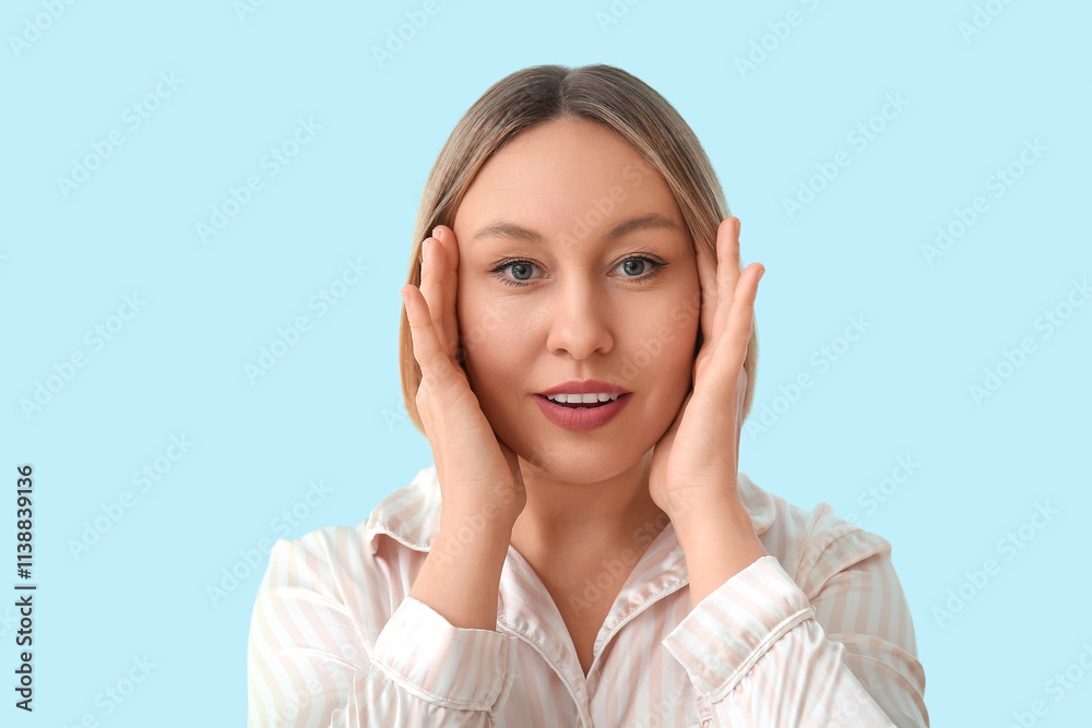 Woman doing face building exercise on blue background Woman doing face building exercise on blue background