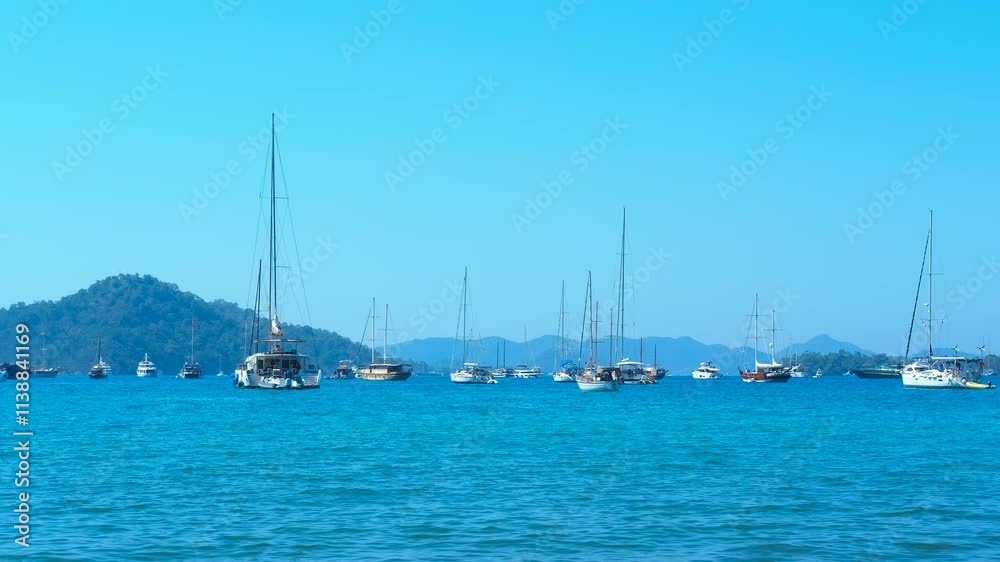 Yachts gracefully anchoring near a serene tropical island. The calm, blue sea and clear sky create an idyllic setting for relaxation and leisure in a beautiful coastal paradise Yachts gracefully anchoring near a serene tropical island. The calm, blue sea and clear sky create an idyllic setting for relaxation and leisure in a beautiful coastal paradise