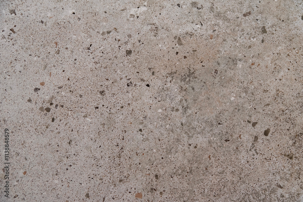 Aged cement wall with coarse texture and scattered dark patches Aged cement wall with coarse texture and scattered dark patches