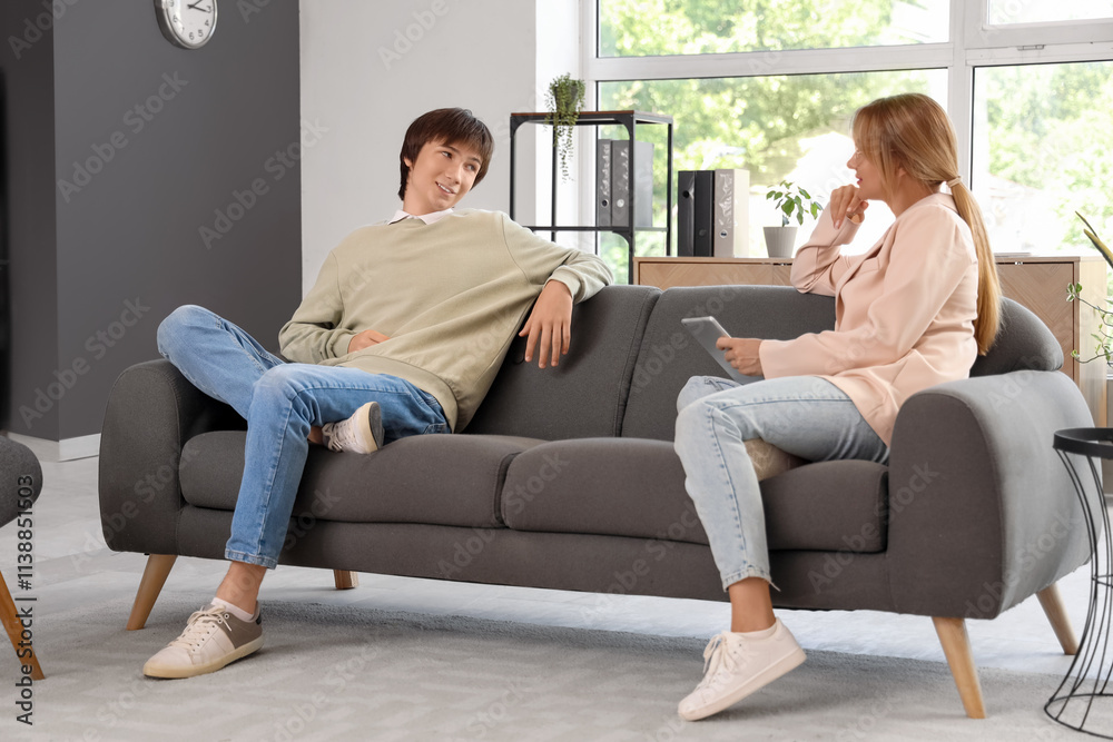 Teenage boy talking to psychologist in office Teenage boy talking to psychologist in office