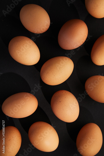 Chicken eggs on black background. View from the top