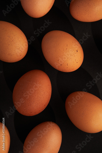 Chicken eggs on black background. View from the top