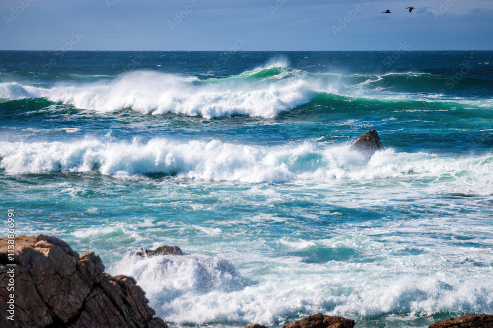 Scenic view of Pacific Ocean waves at the coast seen from Spanish Bay Vista Point, Del Monte Forest, California, USA against blue sky with clouds