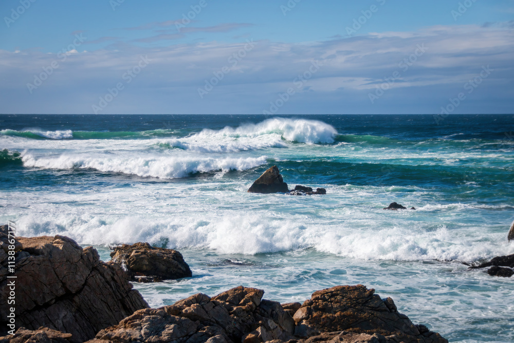 Scenic view of Pacific Ocean waves at the coast seen from Spanish Bay Vista Point, Del Monte Forest, California, USA against blue sky with clouds