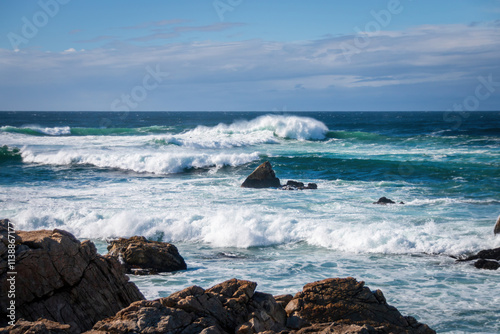 Obraz na płótnie Scenic view of Pacific Ocean waves at the coast seen from Spanish Bay Vista Point, Del Monte Forest, California, USA against blue sky with clouds w salonie