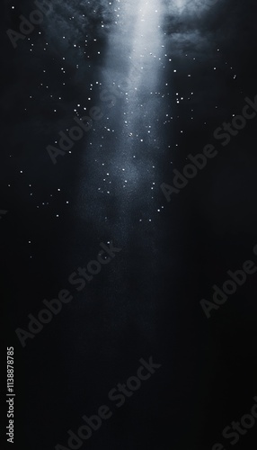 A mysterious black void illuminated by a singular beam of light highlighting airborne particles