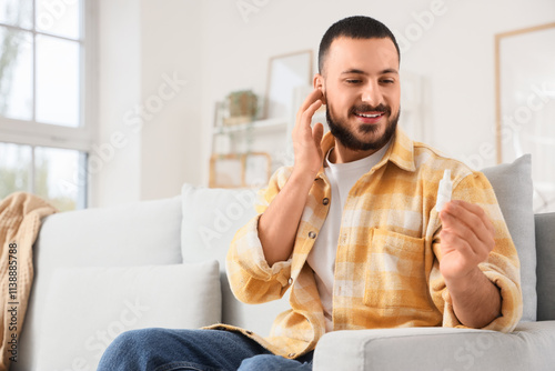 Young man with ear drops si...