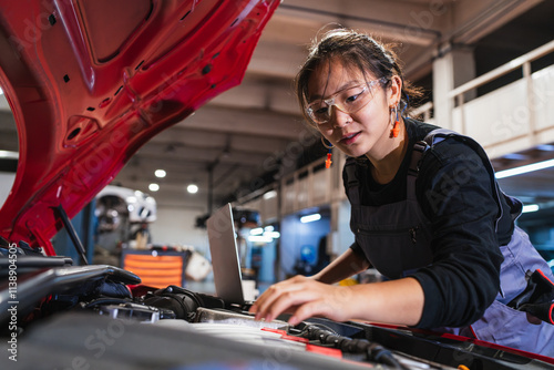 Wallpaper Mural Female chinese mechanic using laptop while repairing car engine in garage Torontodigital.ca