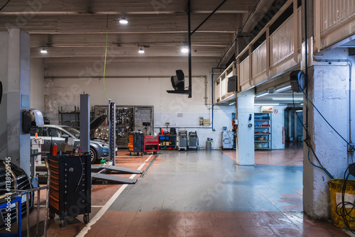 Car repair shop with professional equipment and cars being repaired photo