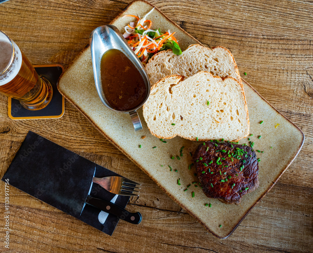 Tasty veal steak served with sauce, bread and fresh vegetable salad, Netherlands cuisine Tasty veal steak served with sauce, bread and fresh vegetable salad, Netherlands cuisine