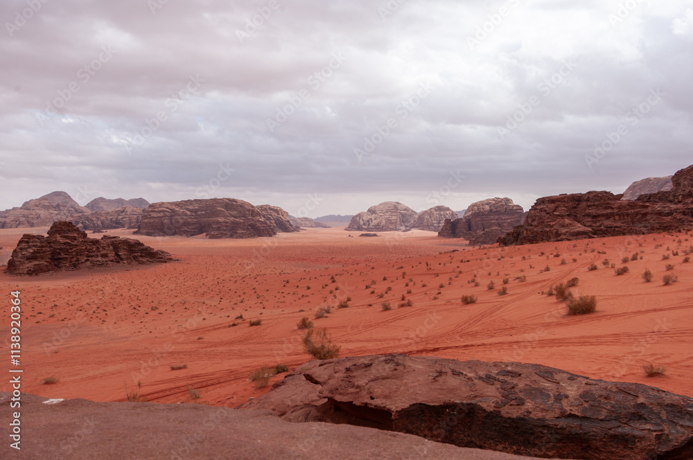 A desert landscape with a rocky outcropping in the foreground A desert landscape with a rocky outcropping in the foreground