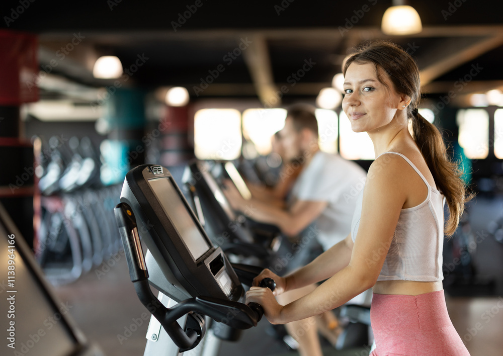 Young woman in sportswear training on exercise bike in gym Young woman in sportswear training on exercise bike in gym
