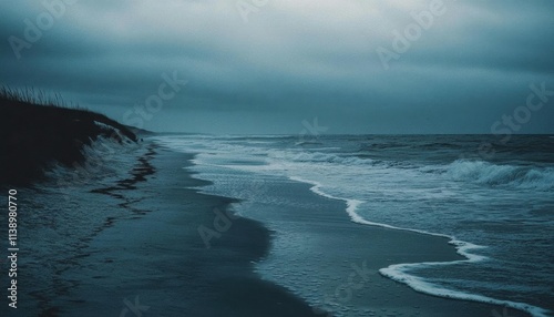 A serene beach scene under a moody, overcast sky with gentle waves.